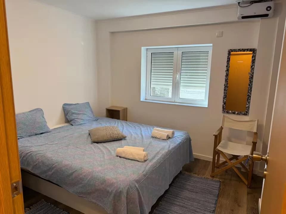 Sodalita kamer met tweepersoonsbed, eenvoudige inrichting, raam en airconditioning aan de muur